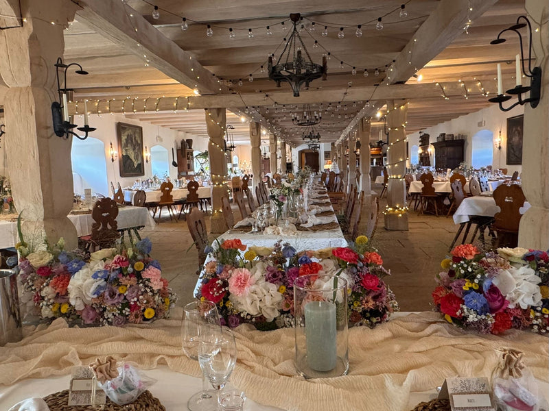 Festlich dekorierte Hochzeitstafel in rustikaler Location mit üppigen Blumenarrangements, Lichterketten und liebevoll gestalteter Tischdekoration vom Tischdekorationsverleih Fulda.