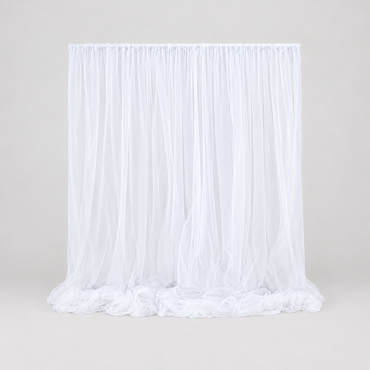 Weißer Stoffvorhang mit weichen Falten und bodenlangem Fall als Backdrop für Traubogen oder Brauttisch bei einer Hochzeit.